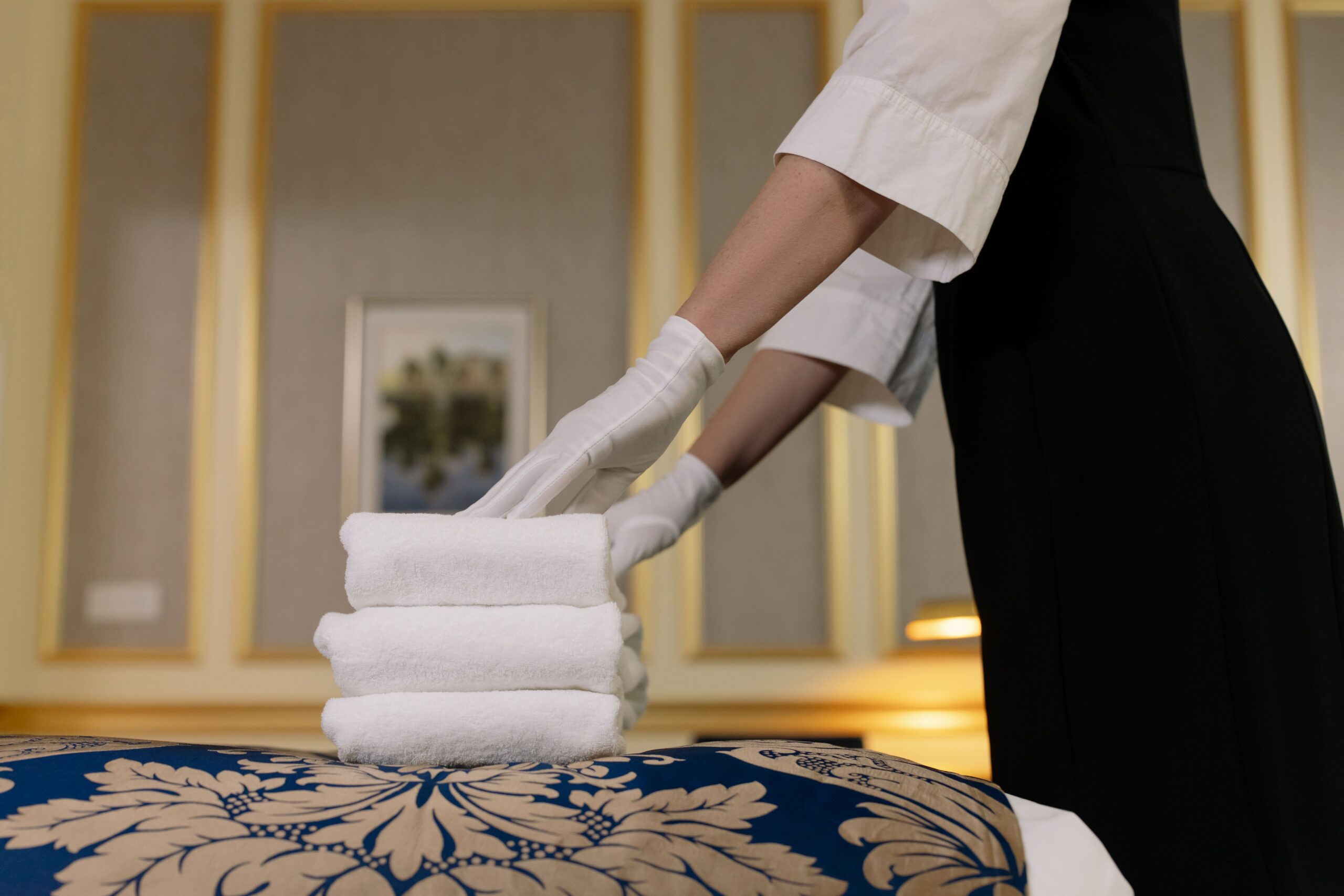 Housekeeper making a bed as part of daily housekeeping job duties
