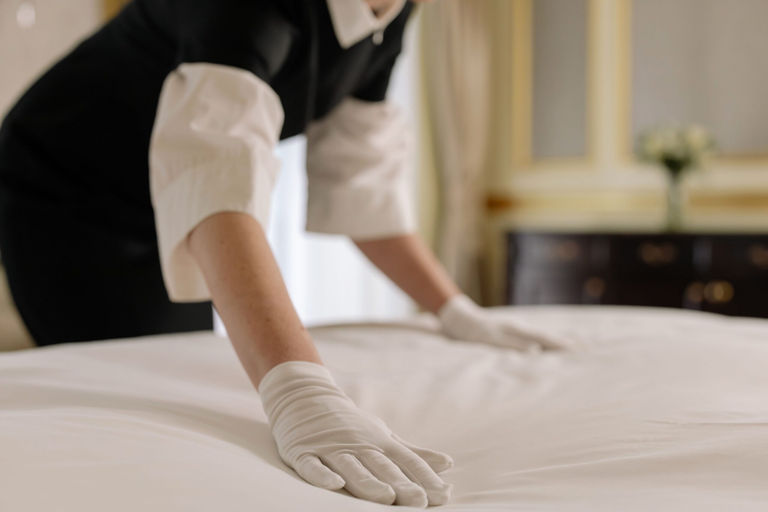 Housekeeping team member folding towels, showing pay and benefits of an entry-level job